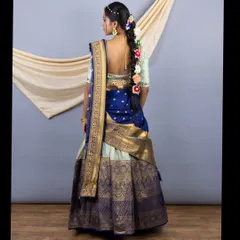The back view of the Pattu lehenga, showing the traditional braid adorned with flowers and the elegant drape of the silk voni (dupatta).