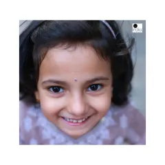 A sweet, close-up portrait of a young girl with a genuine, happy smile. By shooting from her eye level, I connect directly with her, making the portrait feel personal and engaging.
