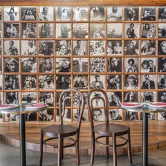At Melthouse cafe, we created a nostalgic, lived-in atmosphere with a gallery wall of black-and-white portraits. This feature wall, paired with classic bentwood chairs, adds a layer of storytelling and old-world charm, making the space feel like a timeless European neighborhood pub.