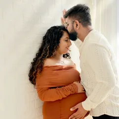 We focus on capturing the quiet, intimate moments between expecting parents. This high-key couple portrait highlights the connection and joy of your journey together in our comfortable studio setting.