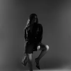 A dramatic full-length silhouette in black and white. This artistic shot focuses on form and mood, creating a powerful fashion statement.