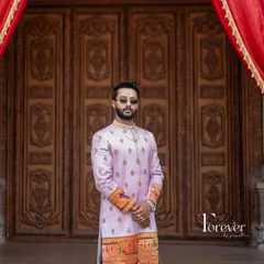 This is a closer look at a bespoke sherwani I crafted from Paitani silk. The soft lavender color is complemented by traditional motifs along the hem and cuffs, making it a standout piece for a groom who values classic elegance.