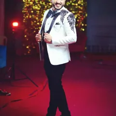 Look sharp and confident at your reception or cocktail event. This client is wearing a custom-tailored white tuxedo jacket with a modern three-piece construction, detailed with unique black embroidery on the lapels and shoulders.