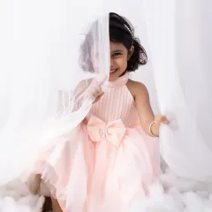 A peek-a-boo smile from behind a sheer curtain. This dreamy setup with soft, white fabrics creates such a sweet and angelic portrait.