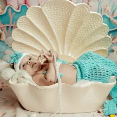Let's bring your dreams to life. For this session, we created a magical underwater world for a tiny mermaid, complete with a seashell bed and delicate pearls. I have many creative themes we can explore.
