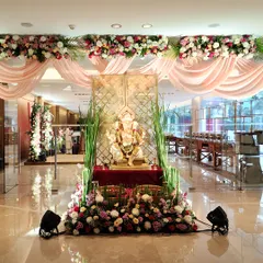 For a traditional and auspicious beginning, we designed this beautiful entrance around a Ganesha idol. The setup includes soft pink drapes, a canopy of flowers, and lush greenery, creating a serene and welcoming focal point.