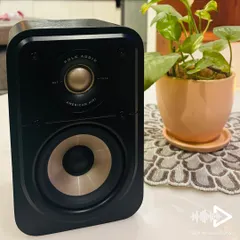 The Polk Audio Signature Elite ES10 compact surround speaker, shown here with its grille off. You can see the high-resolution Terylene dome tweeter and the mica-fortified polypropylene woofer that deliver cinematic sound.