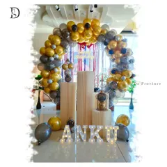 For a sleek and stylish adult birthday party, I used a gold, black, and silver color scheme. This setup features a balloon arch, fluted plinths for the cake, and light-up marquee letters for the name.