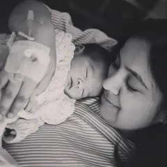 A quiet moment between a new mother and her baby, skin to skin, right in the hospital bed. The intravenous line on her hand is a real part of the birth story. I capture these details to create an authentic memory of this powerful experience.