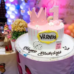 A detailed shot of a pink princess crown-themed first birthday cake. We know the cake is a centerpiece of the celebration, and we photograph it beautifully.