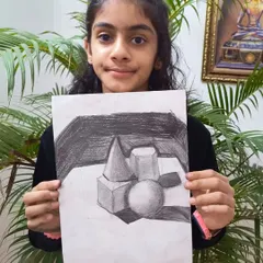 A student shows her advanced charcoal sketch, demonstrating excellent shading and understanding of light on geometric forms.