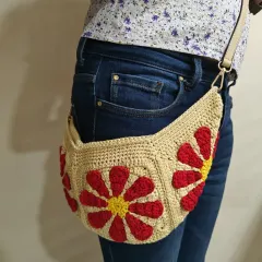 A closer look at the Groovy Daisy bag, showing how the floral granny squares form the main body. The combination of the beige yarn with the bright red and yellow flowers gives it a fun, retro feel.