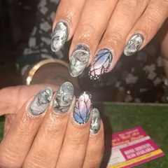 A unique and artistic set combining a grey marble effect with a stunning, stained-glass style butterfly accent nail. This shows how we can mix different art styles in one set.