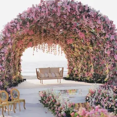 We designed this colossal floral mandap to feel like a natural wonder. The structure, completely covered in thousands of pink and lavender flowers, creates an immersive sanctuary for the wedding ceremony, with the ocean as the backdrop.