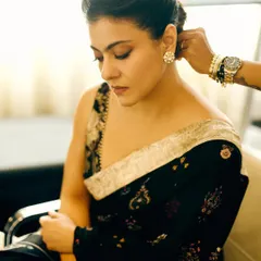 A quiet moment of preparation, as final adjustments are made to Kajol's hair before a photoshoot.