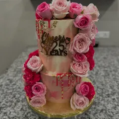 A two-tiered masterpiece for a 25th wedding anniversary, blending rich Belgian chocolate and refreshing Mango Vanilla flavors. The design features a cascade of fresh pink roses and delicate gold leaf for a touch of luxury.