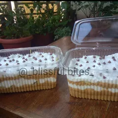My bestselling Banoffee Pie, prepared in large trays for a party. You can see the distinct layers of biscuit, toffee, and cream, topped with chocolate chips for extra texture.