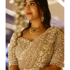 A closer look at the intricate workmanship on Greeshma's reception blouse. The sheer fabric is adorned with a dense pattern of pearls, sequins, and delicate threadwork, creating a rich texture that is both subtle and striking.