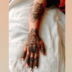A bold and beautiful rose design. This style uses shading to create depth, making the flowers pop. The pattern extends up the arm with a matching floral motif.