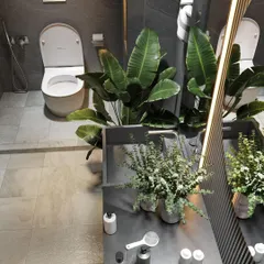 An overhead view of a bathroom layout, showing the placement of the toilet, vanity, and greenery. This perspective highlights the importance of space planning for functionality and easy movement.