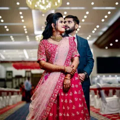 A classic wedding reception look. The couple stands against a beautiful floral wall, ready to greet their guests in a hall that I've decorated to feel grand and welcoming.