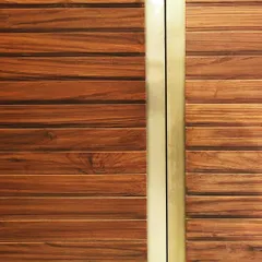 A close-up showcasing the magic of combining Indian Teak wood with brushed brass. This detail from a piece of custom furniture highlights the beautiful contrast between the warm, natural grain of the wood and the sleek, metallic finish.