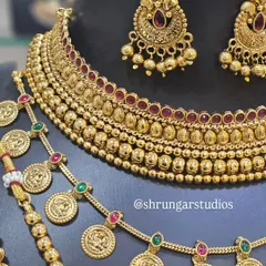 A closer look at the beautiful details of a traditional bridal set, showing the intricate coin motifs and the rich texture of the gold finish.