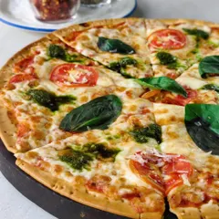 My Margherita pizza with a twist. Fresh tomatoes, mozzarella, and dollops of vibrant pesto on a crispy crust. Scandalously good, no apologies.