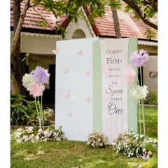 A unique entrance piece designed as a giant storybook. The prop reads "Chapter First - where our little love bug Syora turned One," setting a magical narrative from the moment guests arrive.