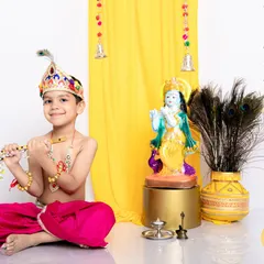 A slightly older boy dressed as Lord Krishna for Janmashtami. We provide age-appropriate costumes and setups to make every child feel a part of the festival.