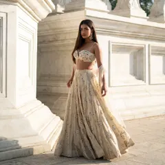 Drench yourself in pure elegance with this ivory lehenga. The soft tones and exquisite handwork make it a timeless piece for any special occasion.