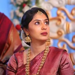 A candid shot capturing the serene elegance of this traditional look. The focus is on defined eyes, a matte mauve-brown lip, and hair pulled back neatly with jasmine flowers.