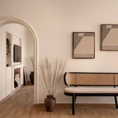 An elegant entryway vignette featuring a custom rattan bench. The arched passage provides a beautiful transition into the living area, demonstrating my focus on creating a natural flow throughout the home.