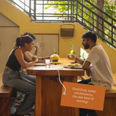 Good food, better conversations. Friends enjoying a meal together in our open-air dining area.