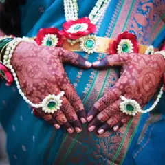 The mom-to-be making a heart shape with her hands over her belly. This pose beautifully captures the love and anticipation of the moment, with the custom mehendi at the center.