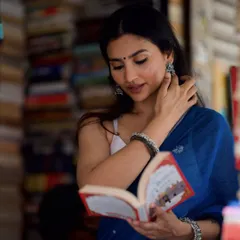 A candid moment from a photoshoot in a Kolkata bookstore. I love creating content that blends fashion with culture, like pairing a modern saree with a sea of books.