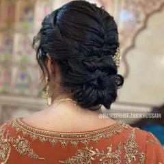 I designed this low-knotted bun with a central braid for a touch of modern elegance. The hairstyle is secured neatly at the nape of the neck, providing a sophisticated foundation for any hair accessories or veil.