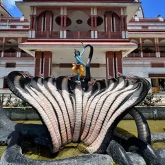 A sculpture of Lord Krishna dancing on the multi-headed serpent Kaliya, located in a water body at the ISKCON Pune temple complex.