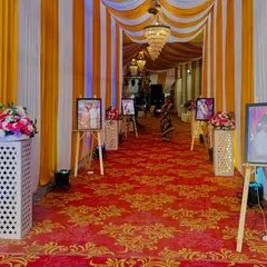 We line the entrance walkway with cherished memories. This path is decorated with a series of the couple's photos on easels, guiding guests into the celebration with a personal and heartwarming touch.