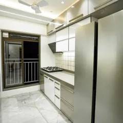 This parallel kitchen design features a clean, modern aesthetic with white and grey cabinets. The layout provides ample counter space and integrates the refrigerator seamlessly.