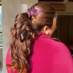A simple way to elevate a classic ponytail is with a touch of glitter. Here, I've added purple glitter gel to the base for a fun, unexpected sparkle that's perfect for a party.