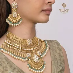 A truly regal bridal set, featuring a multi-layered Polki and pearl necklace with matching oversized earrings. This is a heritage masterpiece, designed to make a bride feel like royalty.