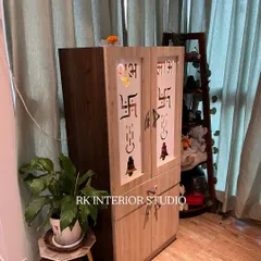 A standalone wooden mandir with custom CNC-cut doors featuring sacred symbols like Om and Swastik. This design provides ample storage at the bottom and a beautiful, traditional pooja space.