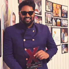 Holding an award from a speaking engagement. My journey has been recognized on various platforms, including TEDx, where I've shared my story and the philosophy behind my art.