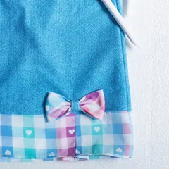 I love mixing textures, like this cool denim paired with a playful plaid hem. The little bow with hearts adds a sweet, unexpected touch to this unique design.