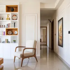 This view shows the clean lines and uncluttered feel of the apartment. I used white wall paneling and a custom bookshelf with pops of wood to add character without overwhelming the space.