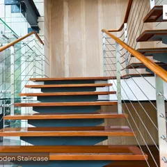A modern wooden staircase with a glass and steel railing. The floating tread design creates a sense of openness, while the wood adds warmth and texture to the space.