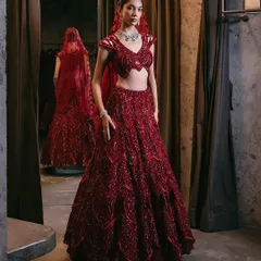 The allure of crimson. This fully embellished lehenga features my signature embroidery, with each stitch a testament to craftsmanship. The matching blouse has modern cut-out shoulder details.