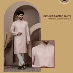 A classic textured cotton kurta in a soft pink. The hand embroidery on the neck adds a touch of craftsmanship. This is a great choice for a comfortable yet stylish festive look.