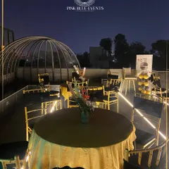 For a more formal or upscale corporate event, I can source and set up stunning venues like this rooftop in Delhi NCR. This evening setup features elegant table settings perfect for a company milestone or offsite dinner.